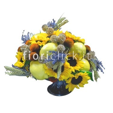 Centrotavola autunnale con materiali particolari e frutta.