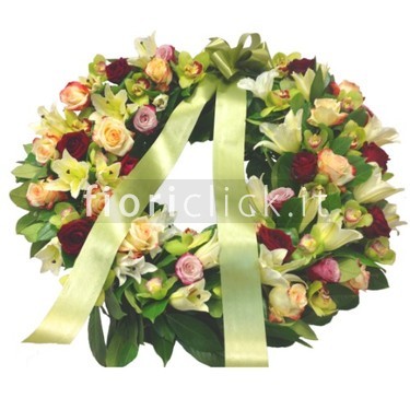 Corona funebre in armonia di colore sul verde.